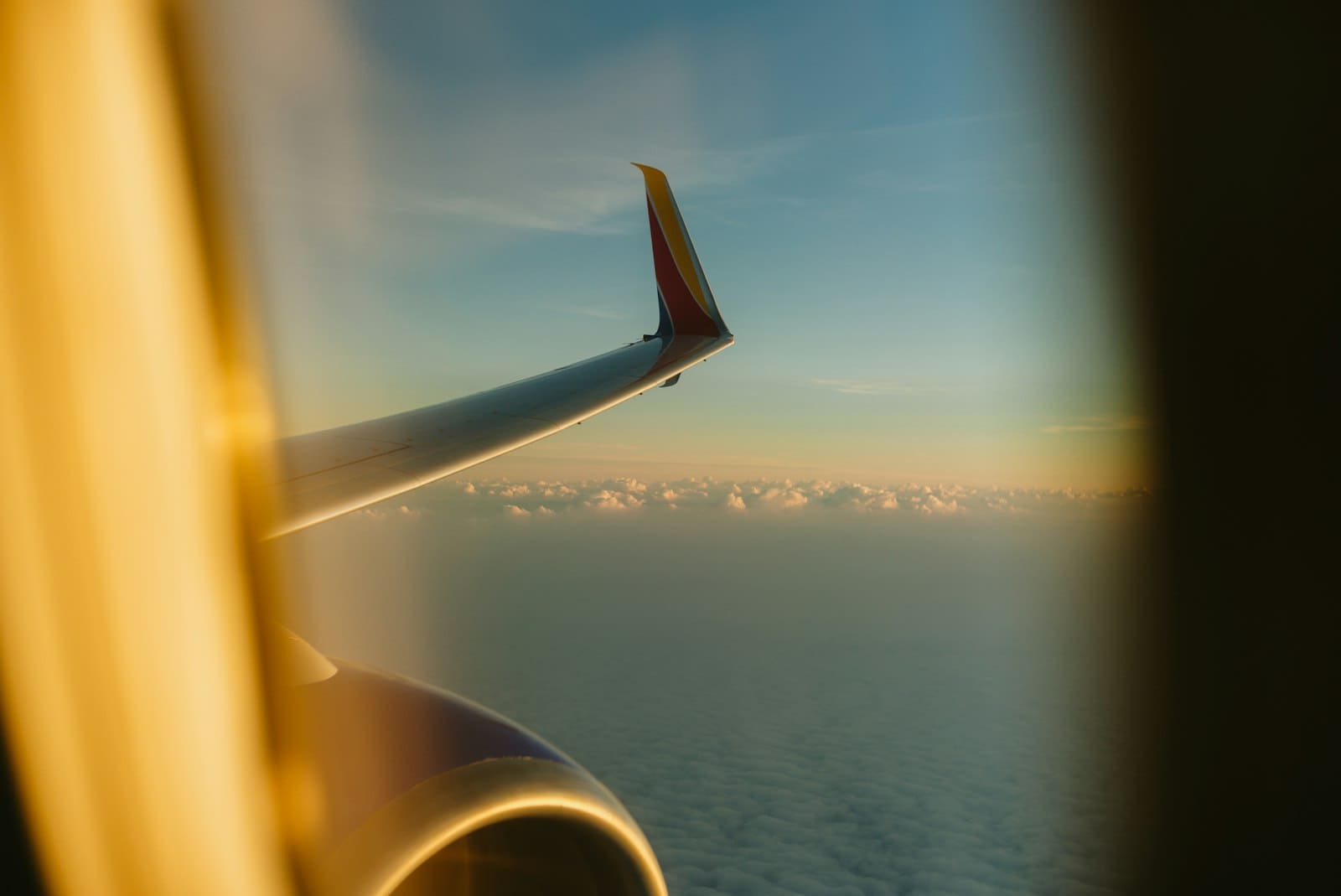 Airplane wing with yellow light and navy sky